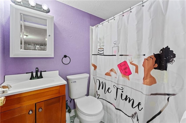 bathroom with a textured wall, toilet, vanity, and a textured ceiling