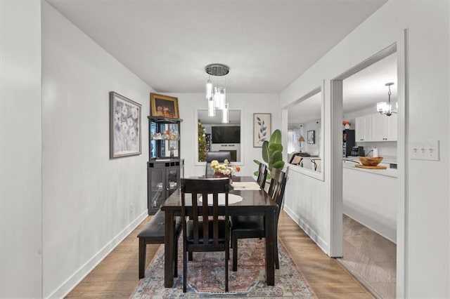 dining area with wood-type flooring and a chandelier