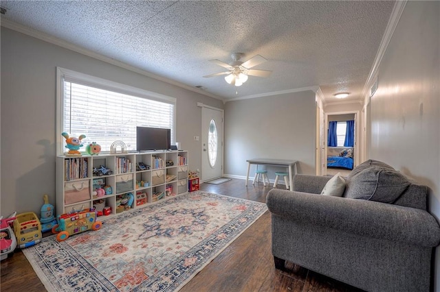 living room with ceiling fan, ornamental molding, dark hardwood / wood-style floors, and a textured ceiling