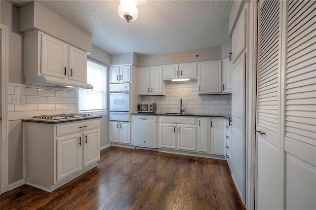 kitchen featuring white cabinetry, appliances with stainless steel finishes, dark hardwood / wood-style flooring, and sink