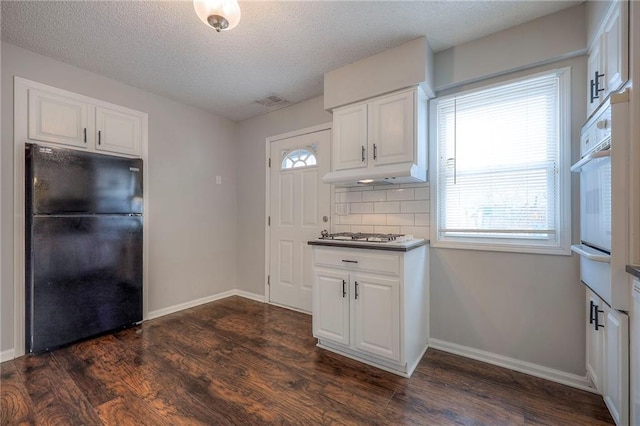 kitchen featuring white oven, black refrigerator, white cabinets, and dark hardwood / wood-style floors