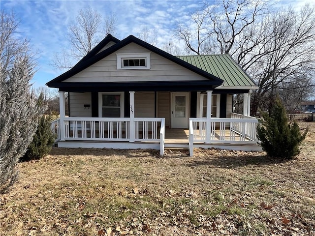 bungalow with covered porch and a front lawn