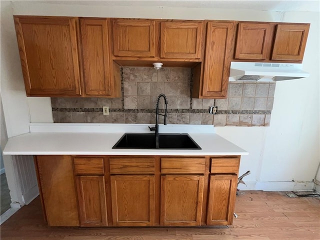 kitchen featuring light hardwood / wood-style floors, sink, and decorative backsplash