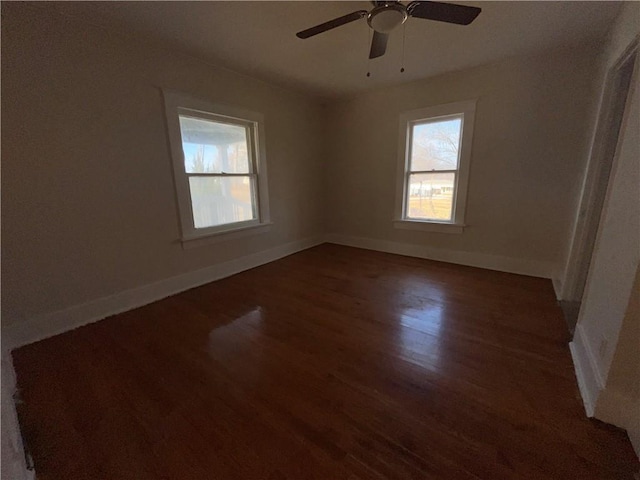 empty room featuring dark wood-type flooring and ceiling fan