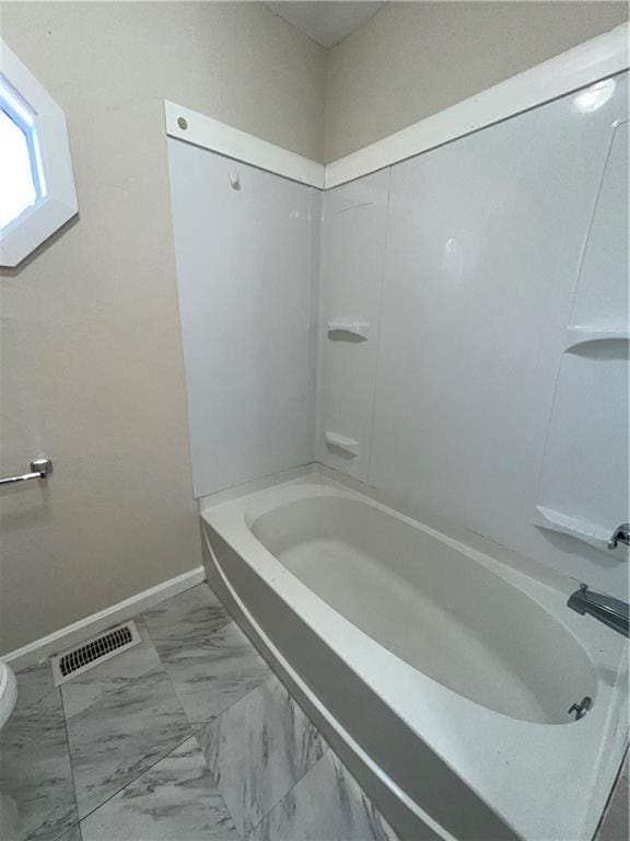 bathroom featuring tub / shower combination and toilet