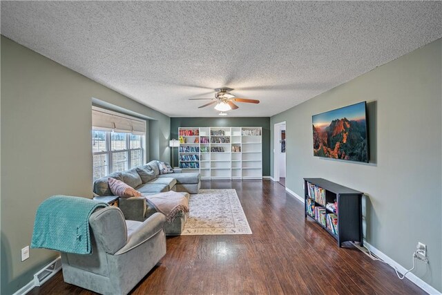 living room with ceiling fan, dark wood-type flooring, and a textured ceiling