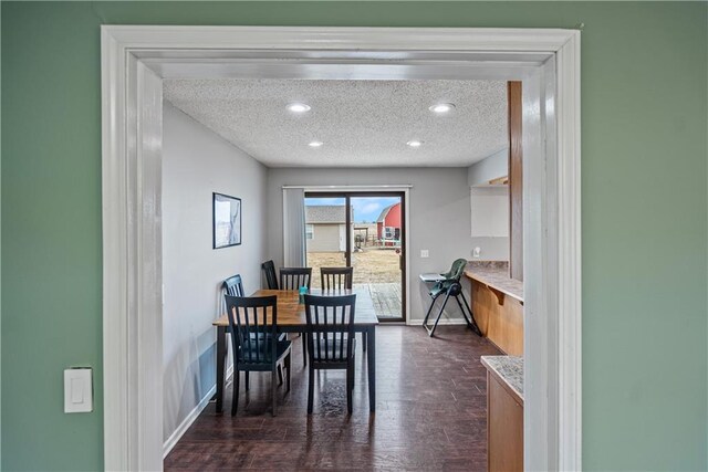 dining room featuring dark hardwood / wood-style floors and a textured ceiling