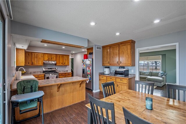 kitchen featuring appliances with stainless steel finishes, dark hardwood / wood-style floors, sink, kitchen peninsula, and a textured ceiling