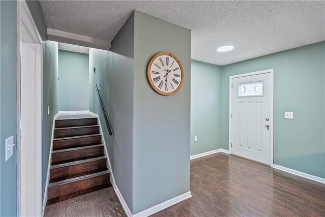 entryway featuring dark wood-type flooring and a textured ceiling