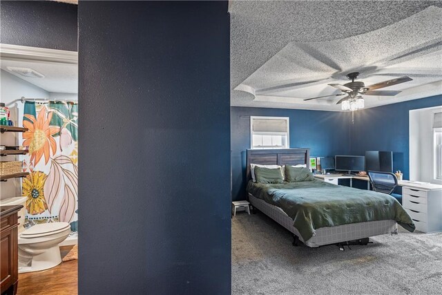 bedroom featuring hardwood / wood-style flooring, ceiling fan, and a textured ceiling