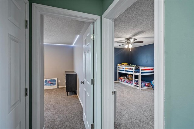 corridor with a textured ceiling and carpet