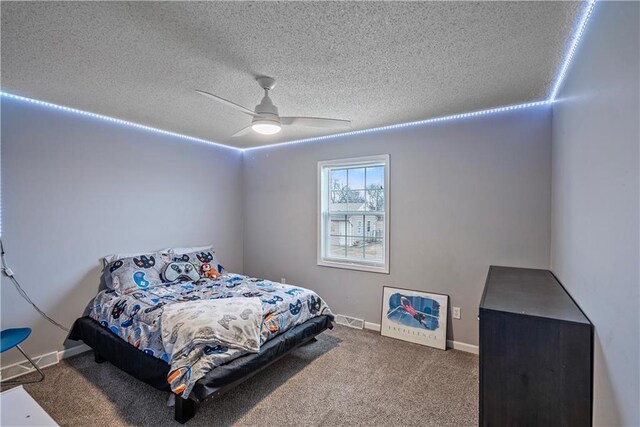 bedroom with ceiling fan, carpet, and a textured ceiling