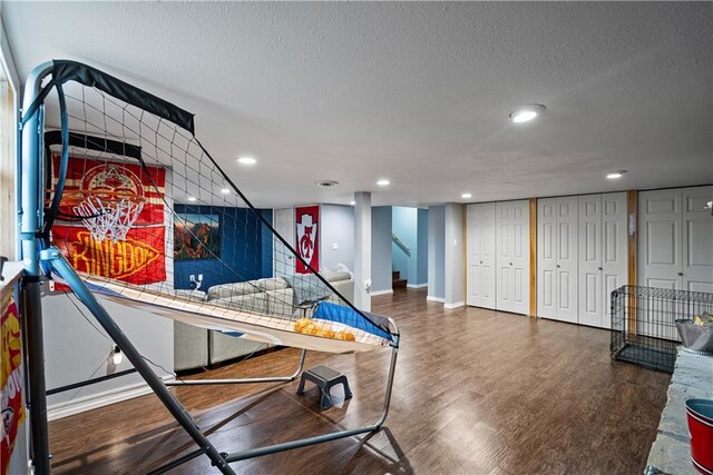 interior space featuring wood-type flooring, a textured ceiling, and two closets