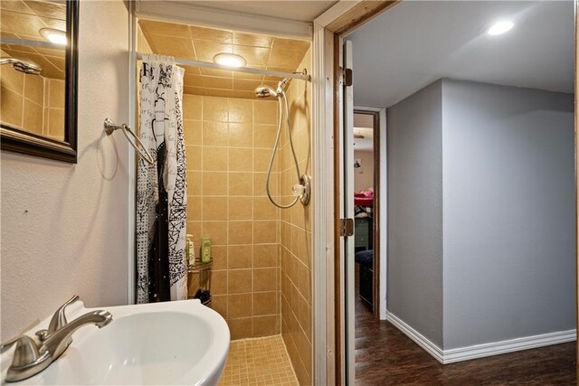 bathroom featuring curtained shower, sink, and hardwood / wood-style floors