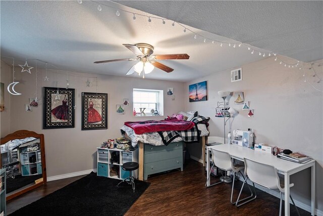 bedroom with ceiling fan, dark hardwood / wood-style floors, and a textured ceiling