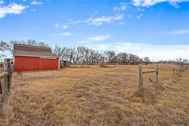 view of yard featuring an outdoor structure and a rural view