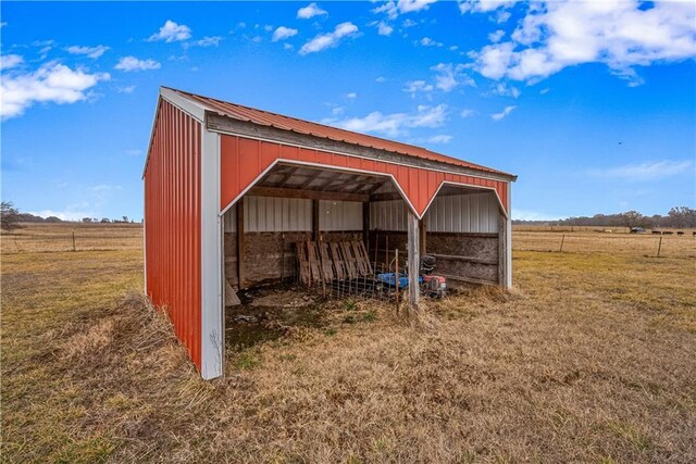 view of outdoor structure featuring a lawn and a rural view