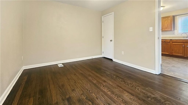 unfurnished room with sink and hardwood / wood-style flooring