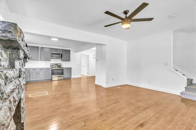 living room featuring ceiling fan and light hardwood / wood-style floors