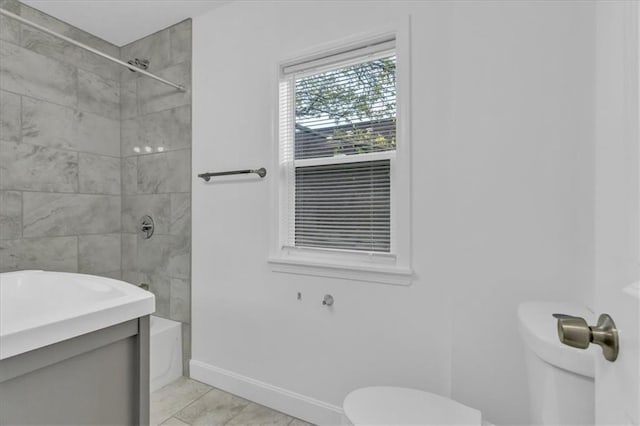 full bathroom featuring vanity, tiled shower / bath, and toilet