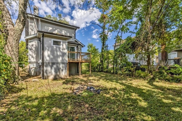 rear view of property with a yard and a deck