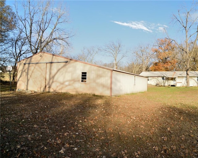 view of side of home featuring an outdoor structure and a yard