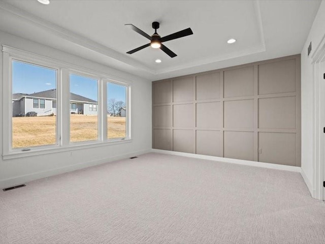 unfurnished bedroom with carpet floors, visible vents, a tray ceiling, and recessed lighting