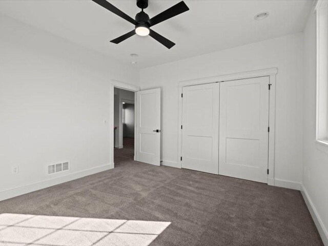 unfurnished bedroom with ceiling fan, carpet floors, visible vents, baseboards, and a closet