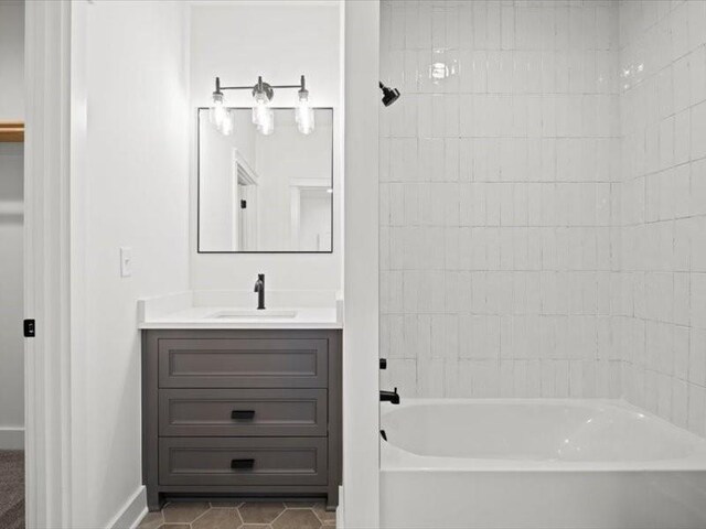 bathroom with baseboards, vanity, shower / bathtub combination, and tile patterned floors