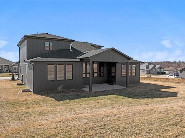 back of property featuring a patio area and a lawn