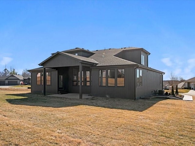 rear view of property featuring a lawn and a patio