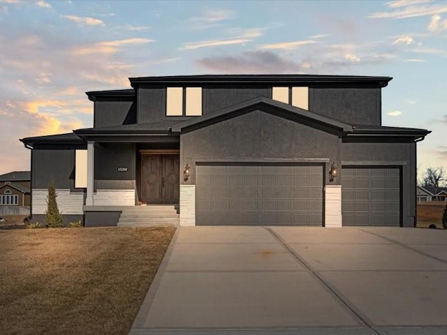 view of front of property with a garage, driveway, and stucco siding