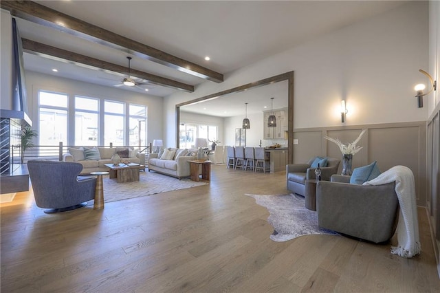 living room with ceiling fan, hardwood / wood-style floors, and beam ceiling