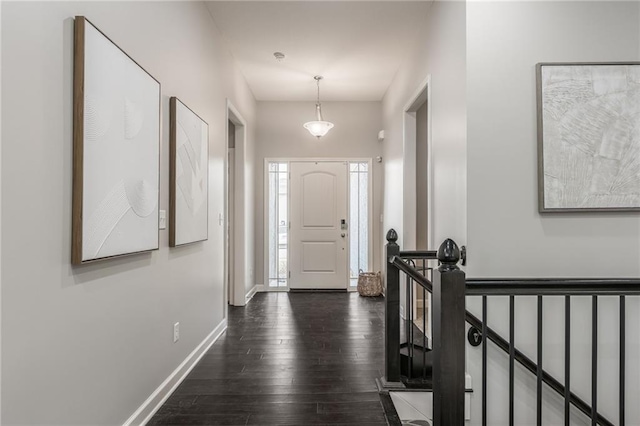 foyer entrance with baseboards and dark wood-style flooring