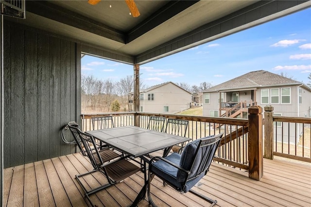 wooden deck with ceiling fan, a residential view, and outdoor dining space