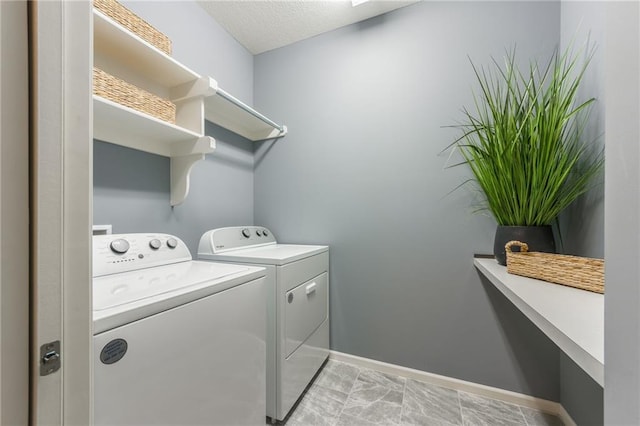 washroom featuring a textured ceiling, laundry area, independent washer and dryer, and baseboards