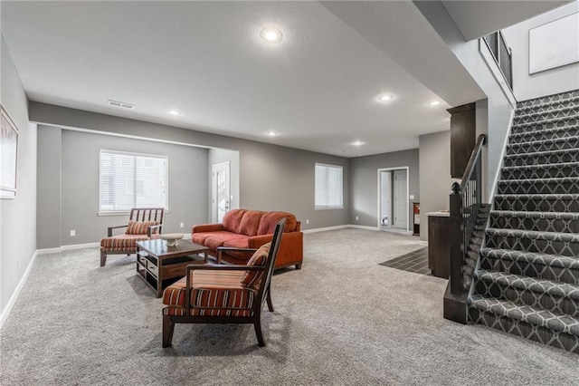 living room featuring stairway, carpet flooring, a wealth of natural light, and baseboards