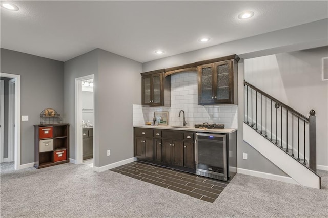 bar with wine cooler, dark colored carpet, stairway, decorative backsplash, and a sink