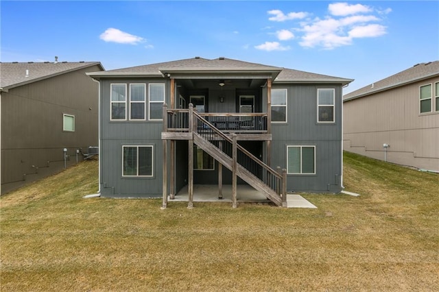 back of property with stairs, a deck, and a lawn