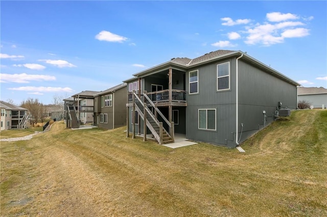 rear view of property with a wooden deck, stairway, central AC, and a yard