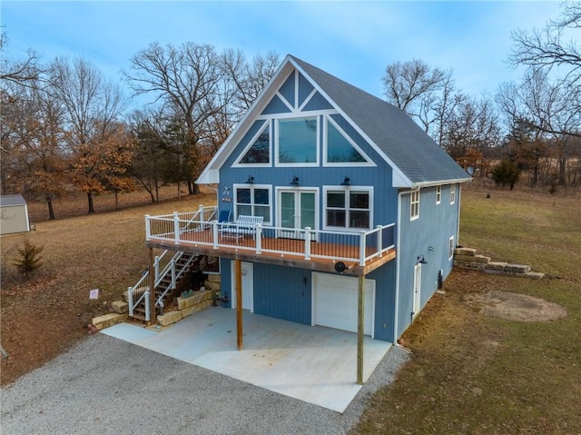 back of house with a wooden deck and a garage