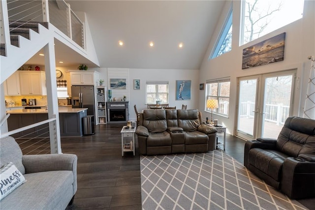 living room with dark wood-type flooring, high vaulted ceiling, and french doors