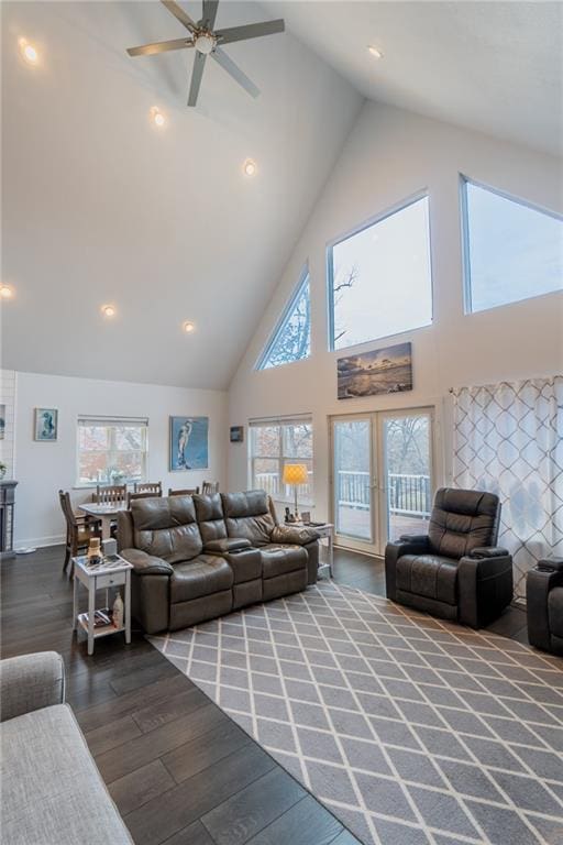 living room with hardwood / wood-style flooring, ceiling fan, and high vaulted ceiling