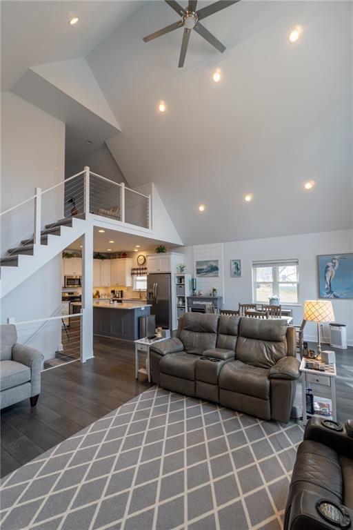 living room featuring ceiling fan, dark hardwood / wood-style floors, and high vaulted ceiling