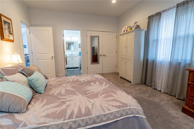 bedroom with ensuite bathroom and carpet