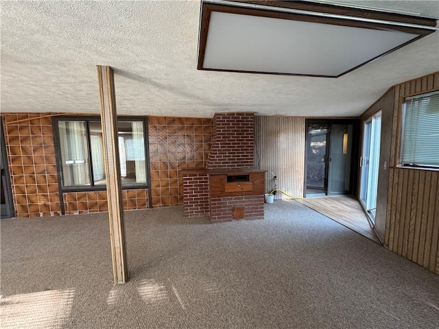 unfurnished living room with carpet flooring and a textured ceiling