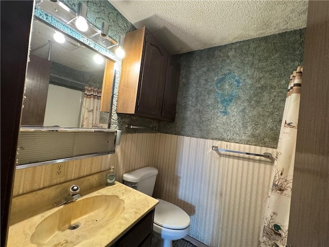 bathroom featuring vanity, a textured ceiling, and toilet