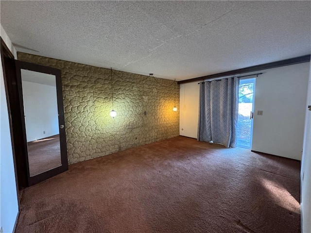 carpeted empty room featuring a textured ceiling