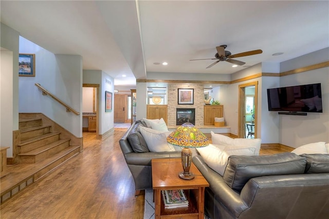 18402 W 64th St, Shawnee, KS 66218 - living area with light wood-style flooring, ceiling fan, a fireplace, baseboards, and stairway