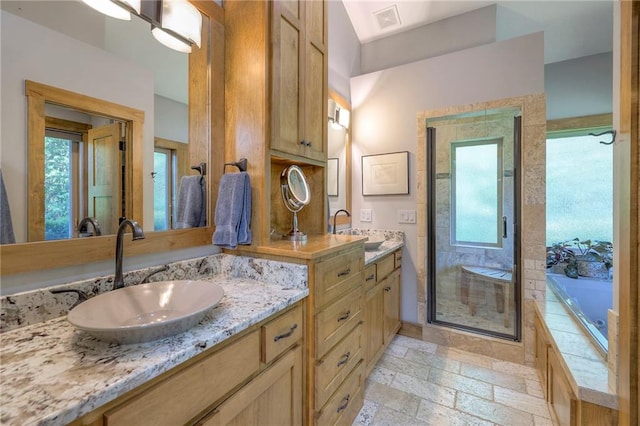 18402 W 64th St, Shawnee, KS 66218 - bathroom with healthy amount of natural light, a stall shower, stone tile flooring, and a garden tub